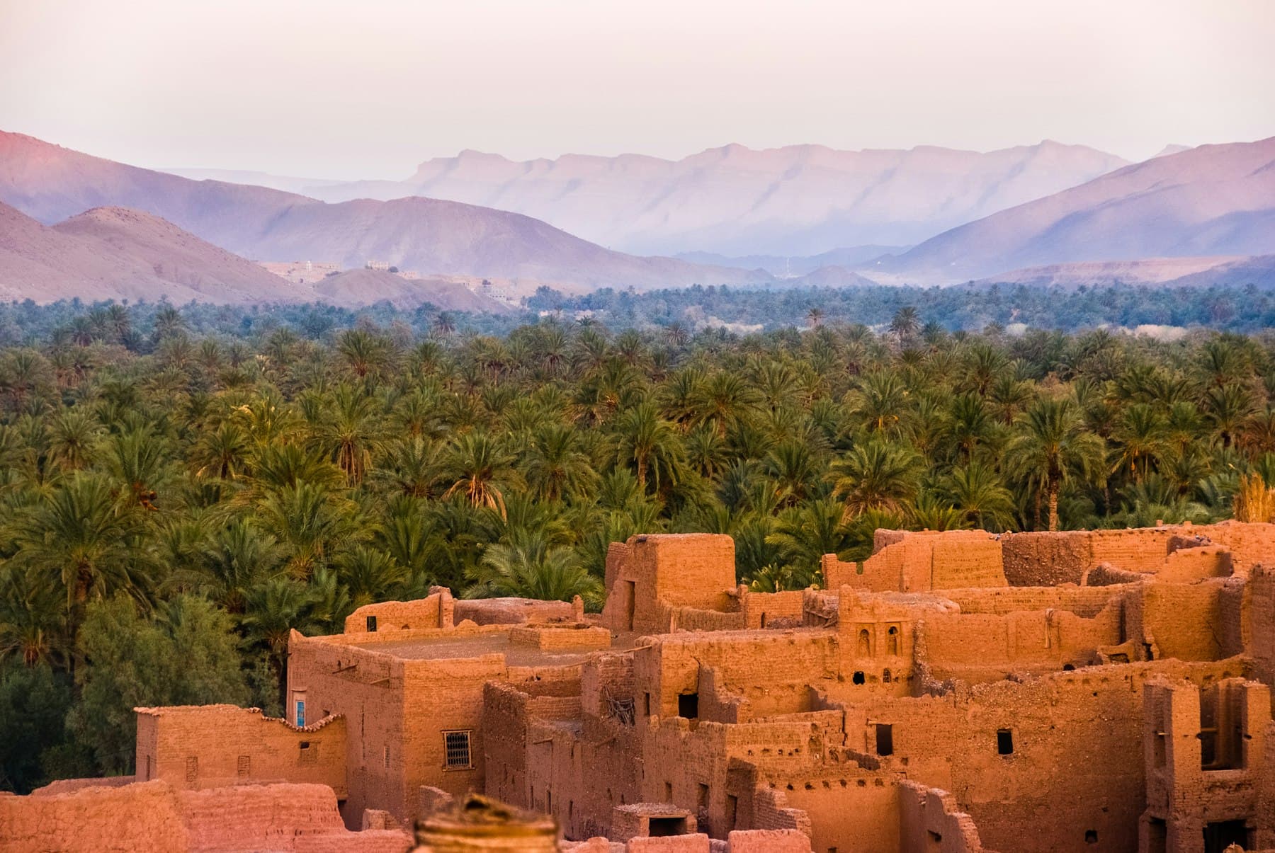 Atlas mountains with terraced villages under a hard, clear sky.