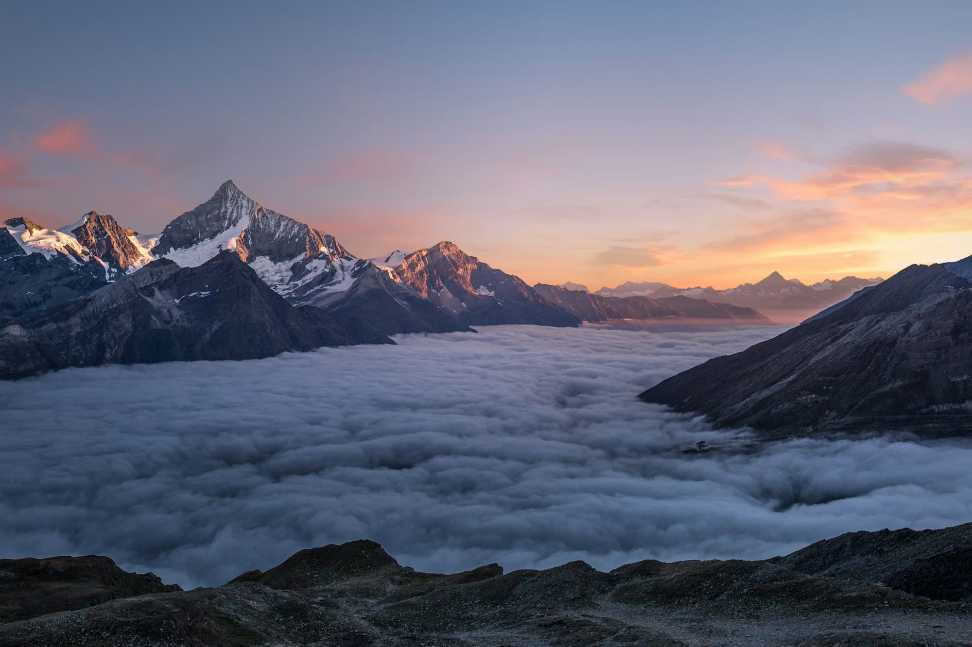 Granite towers above a glacial lake, wind streaking the water.